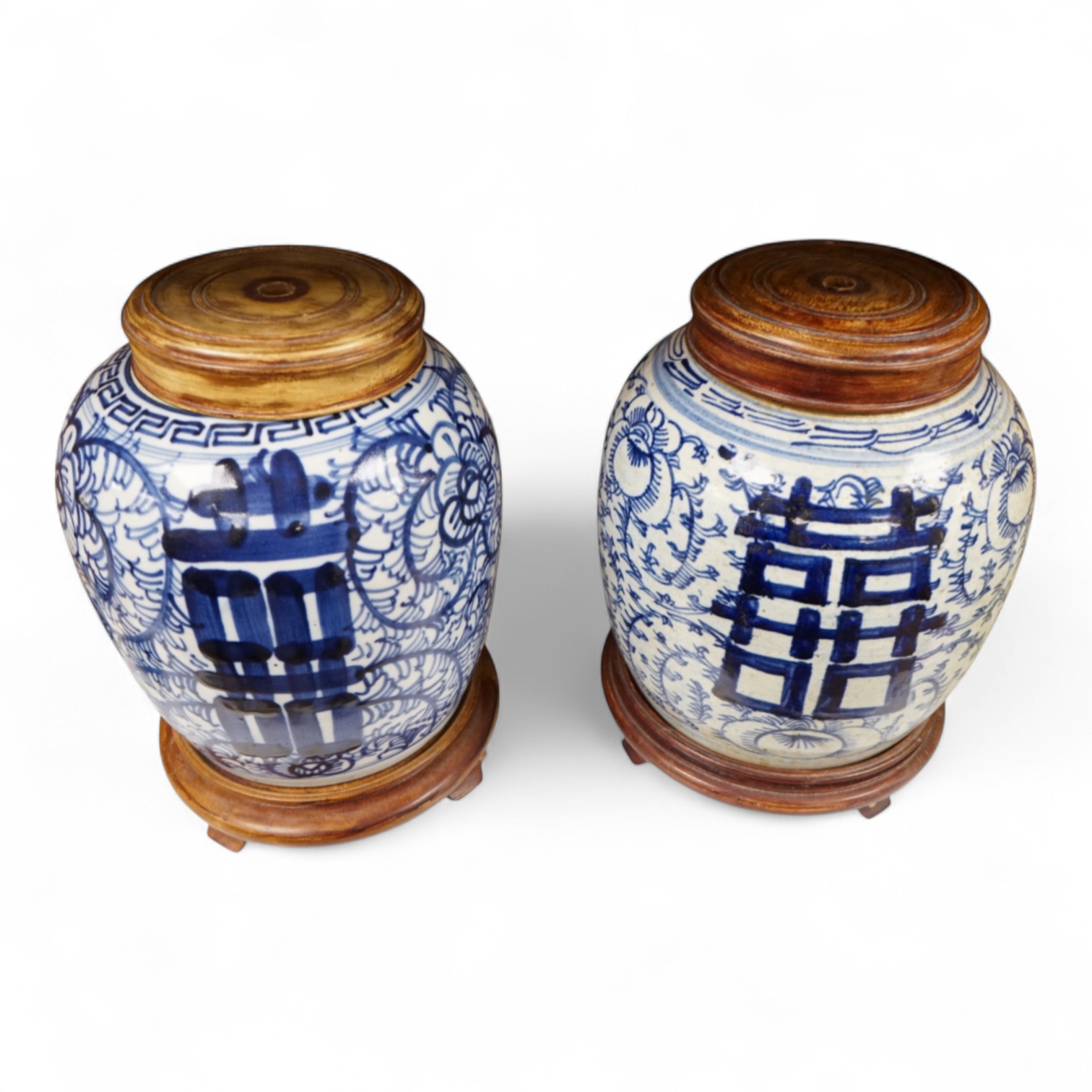 Two Chinese blue and white jars with hardwood stands and covers, 28cm high